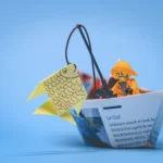 Cette Legography, le photographe a mis en scène un bateau en origami et un lego qui pêche un poisson en origami.