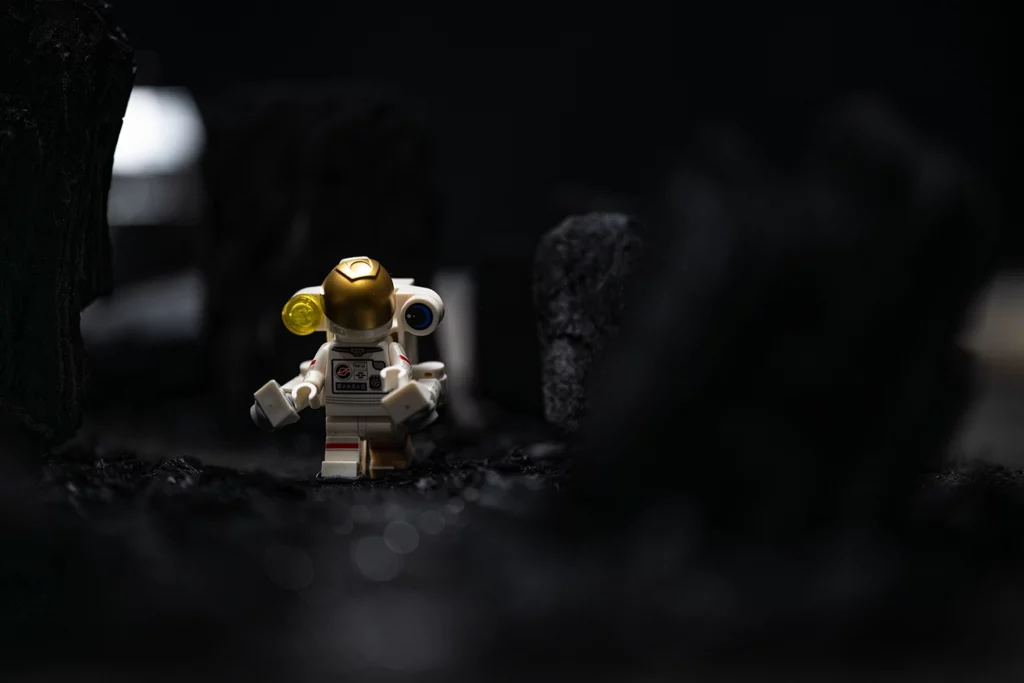 Cosmonaute LEGO explorant une planète faite de charbon de bois